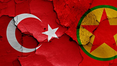 The flags of Turkey and the Kurdistan Workers' Party (PKK) are painted on a cracked wall.