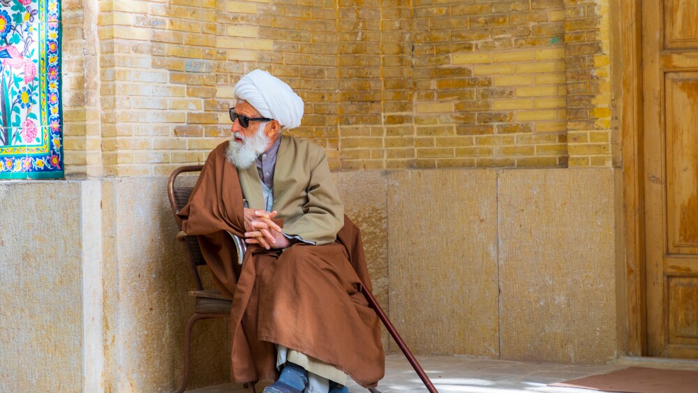 An ayatollah sits outside a religious school in Shiraz, Iran.
