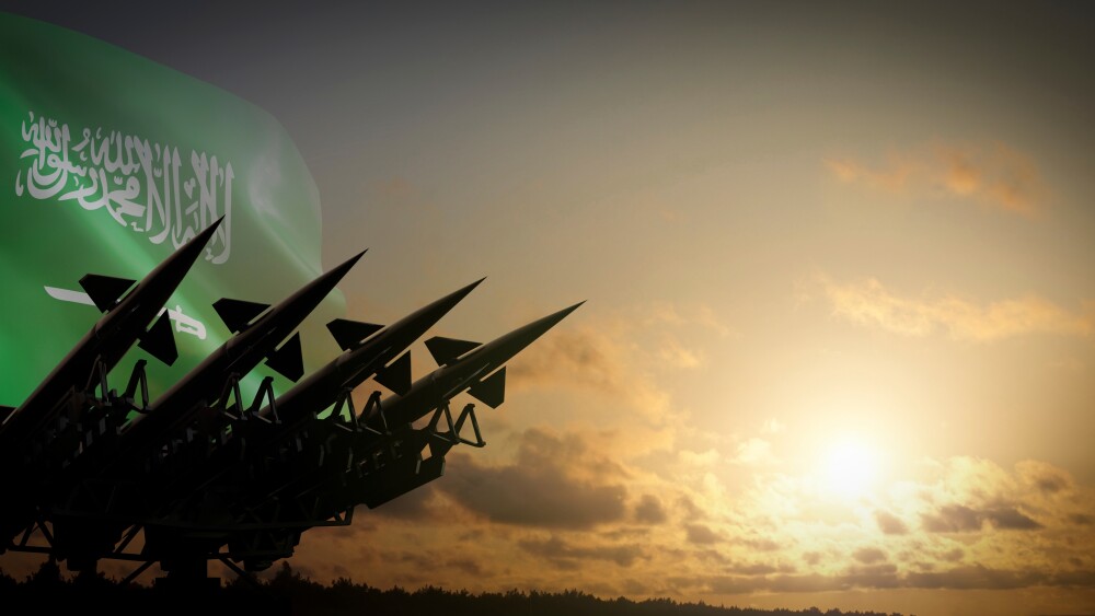 The Saudi flag flies behind missiles.