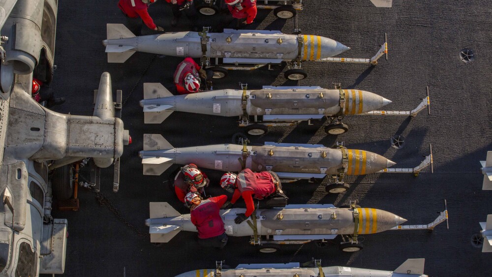 U.S. Sailors prepare to stage ordnance on the flight deck of the aircraft carrier USS Abraham Lincoln in support of Operation Epic Fury.