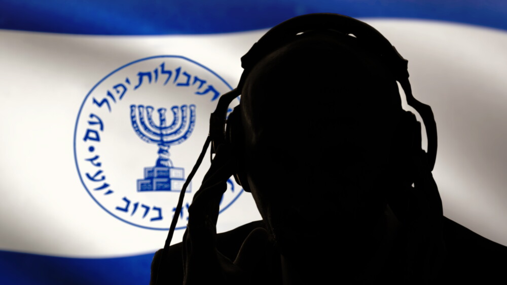 An Israeli intelligence operative works in front of the flag of the special services.