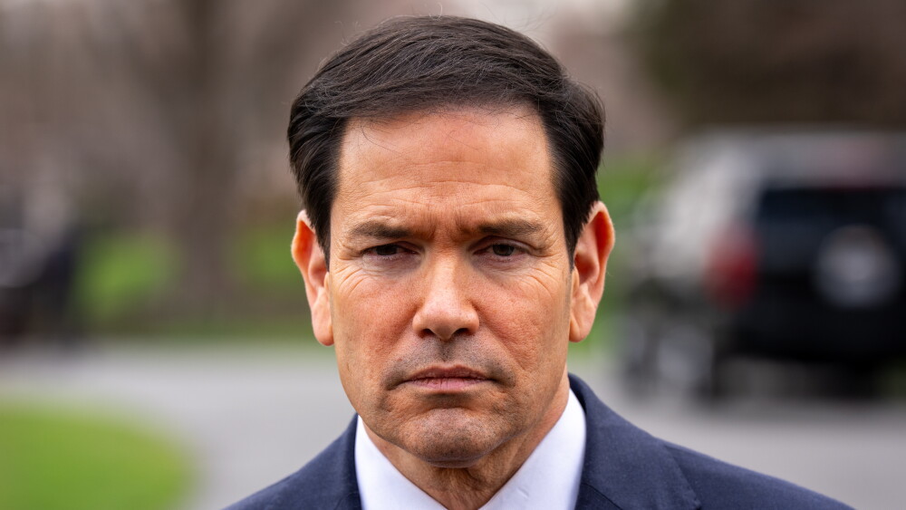 President Donald Trump recognizes that American investment is key to peace. But dire warnings increase insurance rates and dissuade businessmen who may not realize the warnings are decades out of date. Image: Secretary of State Marco Rubio speaking to reporters outside the Oval Office at the White House; March 20, 2026.