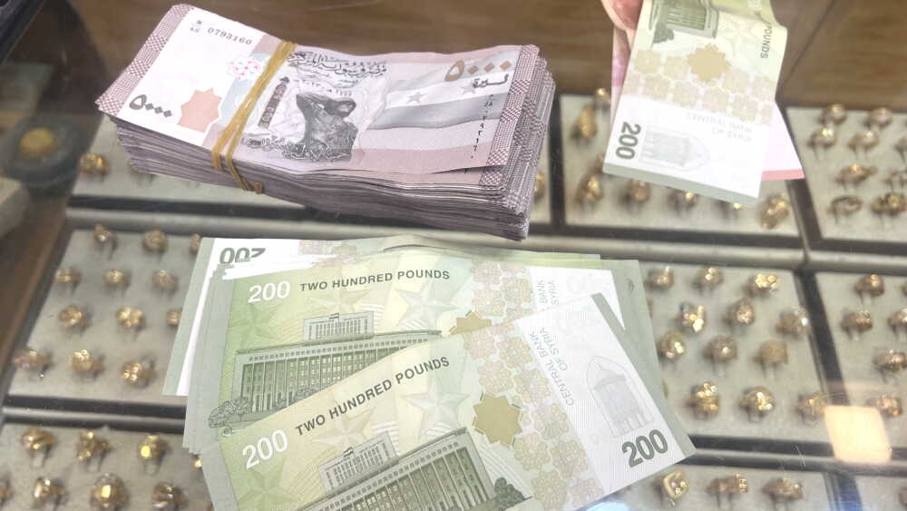 A combination of old bank notes (top left: the old 5000 note mentioned earlier) and new bank notes (primarily 200 new Syrian pound notes, each one equivalent to 20,000 in the old currency). These notes were received at a jewelry store as an exchange for U.S. dollars.