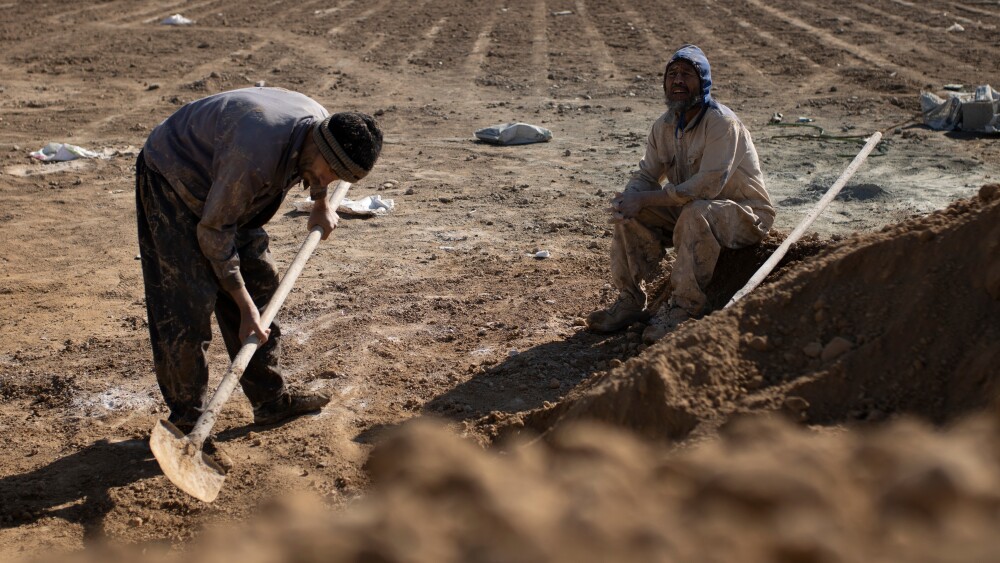Afghan immigrant workers at a cemetery in Tehran, Iran.