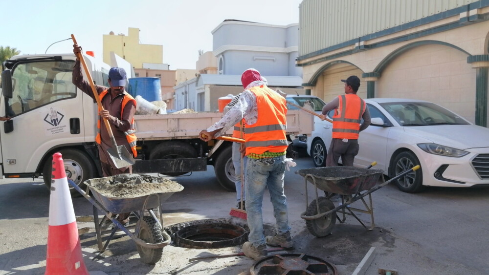 Migrant workers perform maintenance on an underground water drainage system in Al-Ahsa, Saudi Arabia.