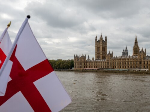 The flag of St. George files across the Thames from the Houses of Parliament in London. For those flying it today, the flag represents pride in being English—reclaiming a symbol of national unity, heritage, and patriotism.