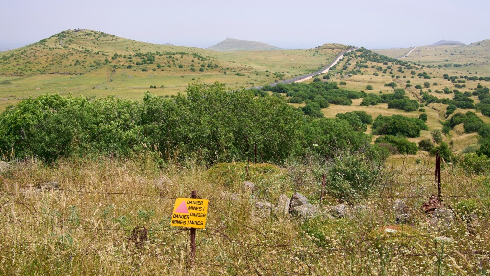 The restricted military zone along border between Israel and Syria in Golan Heights. A sign warns "Danger mines."