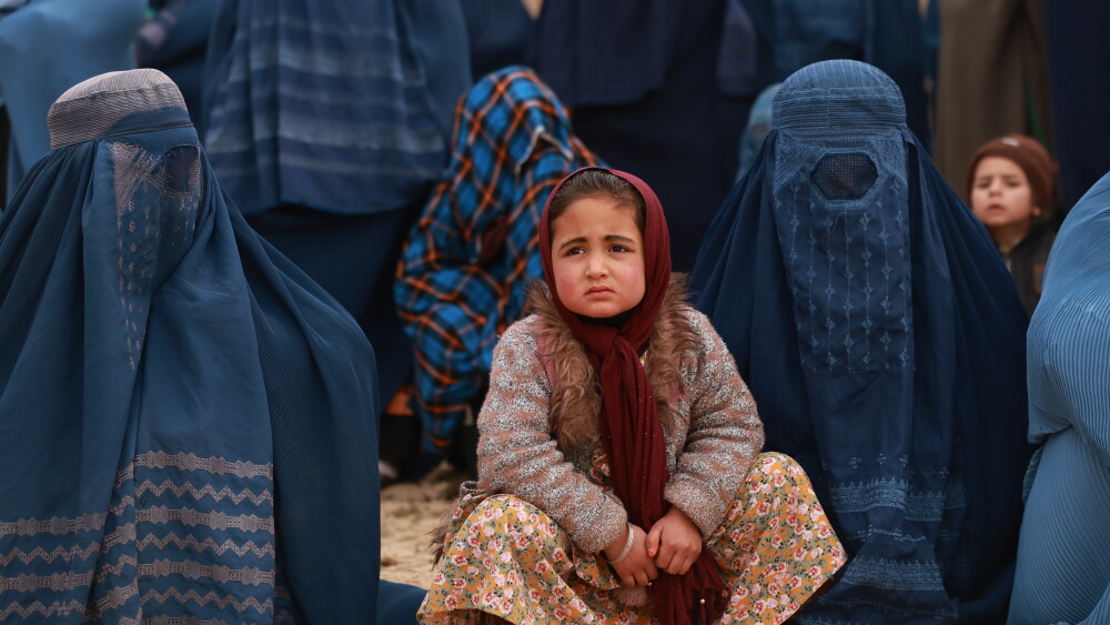 A young girl in Kabul, Afghanistan, is surrounded by women in burqas.