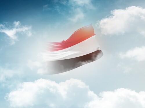 The flag of Yemen appears to dissolve in the clouds.