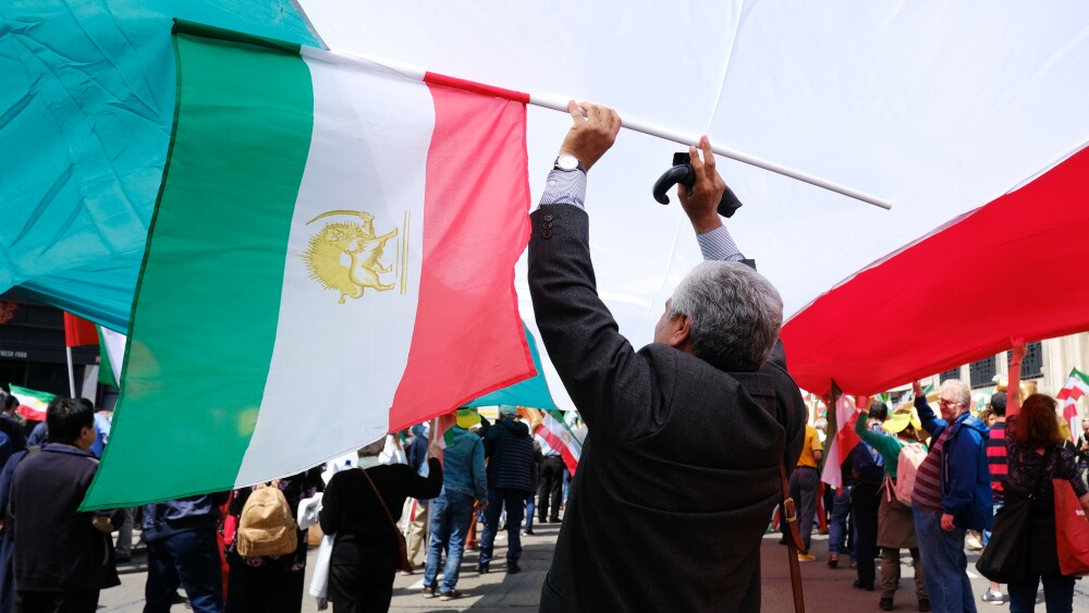 Protesters hold Iranian flags at a demonstration in Belgium against the Islamic Republic.