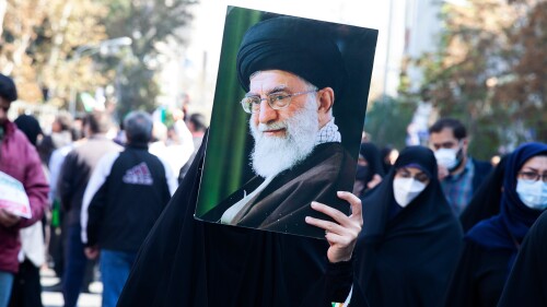 On Nov. 4, 2022, the Day of Fighting Arrogance, a woman carries a photo of Supreme Leader Ali Khamenei in Tehran.