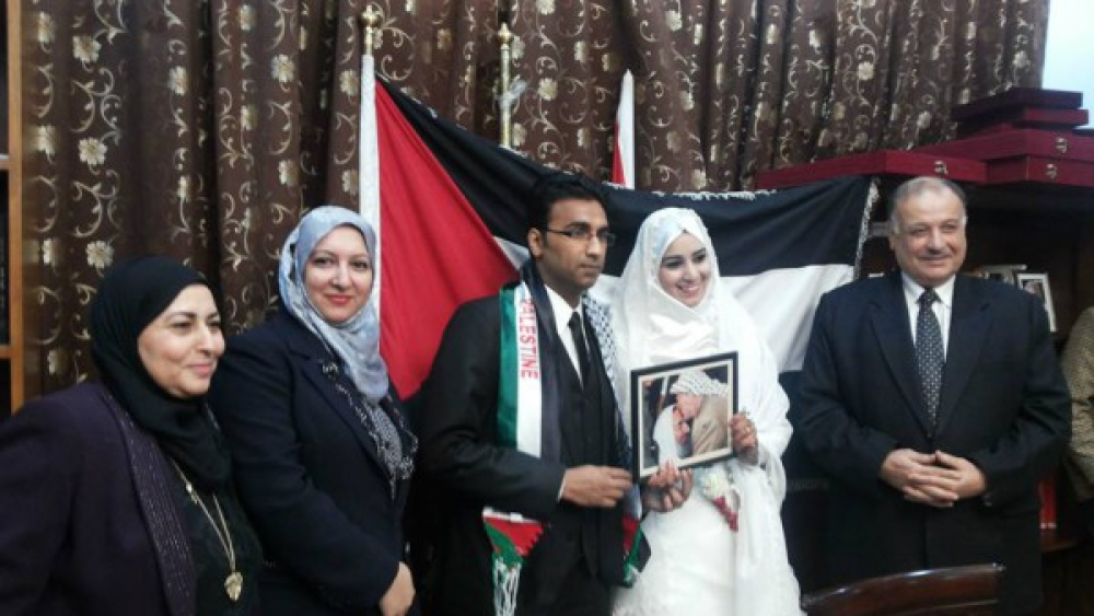 Saleh and Suri at their wedding, holding an image of the former PLO leader Yasser Arafat kissing the forehead of Ahmed Yassin, founder of the terrorist organization Hamas. Source: www.camera.org/article/politico-runs-cover-for-hamasniks-at-georgetown/