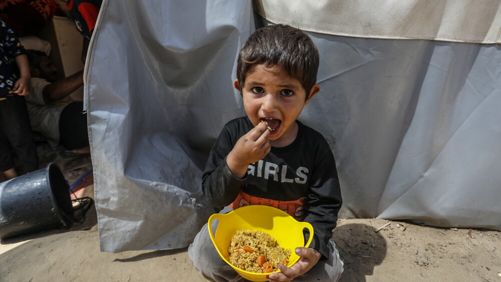 A child eats food provided by an aid organization in the central Gaza Strip in June 2024.