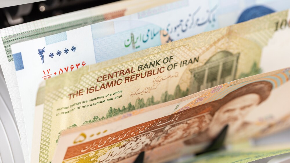 A machine counts Iranian rial banknotes.