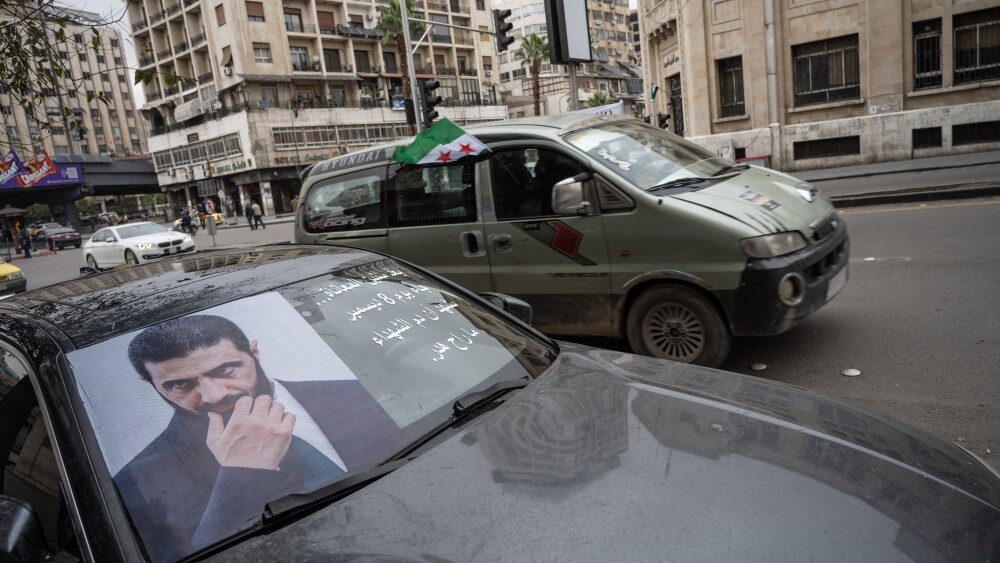 A car in Damascus, Syria, bears a poster with a photo of interim President Ahmed al-Sharaa in December 2025.