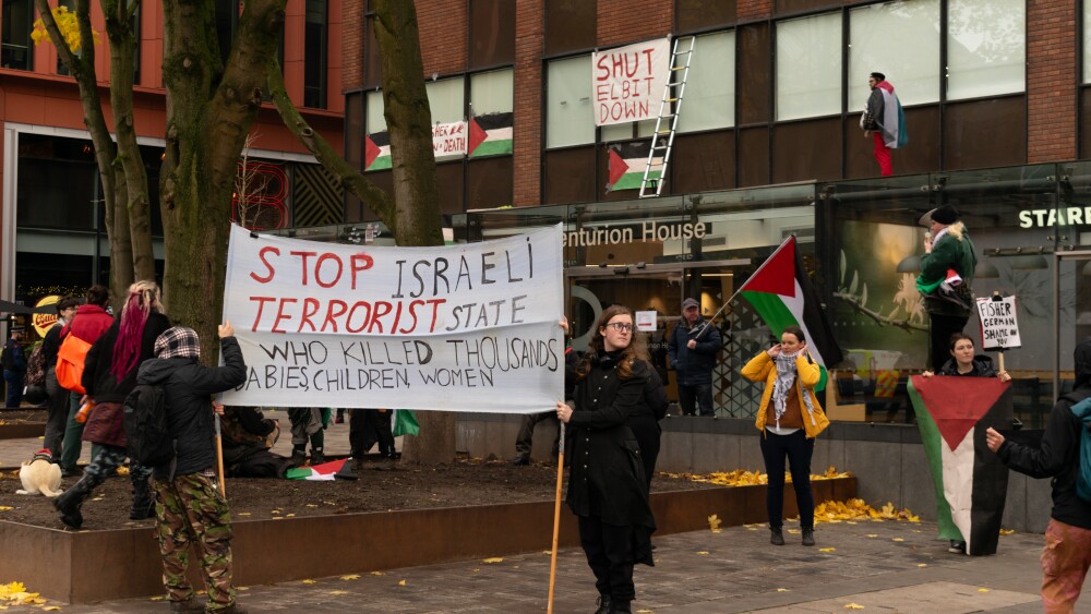 Anti-Israel leftists protest against Israeli defense contractor Elbit Systems in Manchester, England in November 2023, weeks after Hamas murdered 1,200 Israelis, many of them peace activists, during the October 7 massacre. Islamist organizations in the United Kingdom have come to the defense of Palestine Action, a group which has targeted Elbit with protests and vandalized U.K. military equipment.