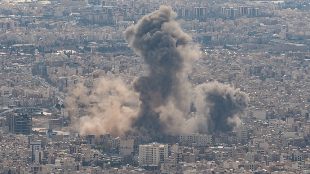 Large columns of smoke billow above residential neighborhoods following U.S. and Israeli airstrikes in Tehran, Iran, on March 12, 2026.