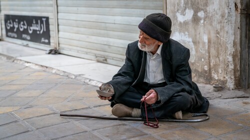 An old man begs in the street in Iran. Sixty percent of Iranians live below the poverty line.