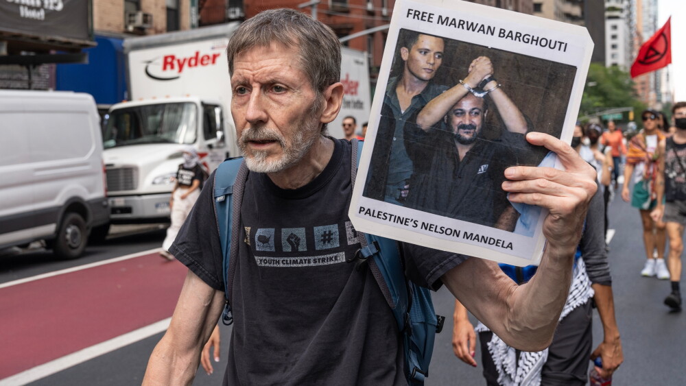 A protester in Midtown Manhattan carries a photo of Marwan Barghouti on Sept. 2, 2024. Barghouti was convicted of five counts of murder by an Israeli court in 2004 for three terrorist attacks that killed four Israelis and a Greek Orthodox monk and sentenced to five life terms plus 40 years.