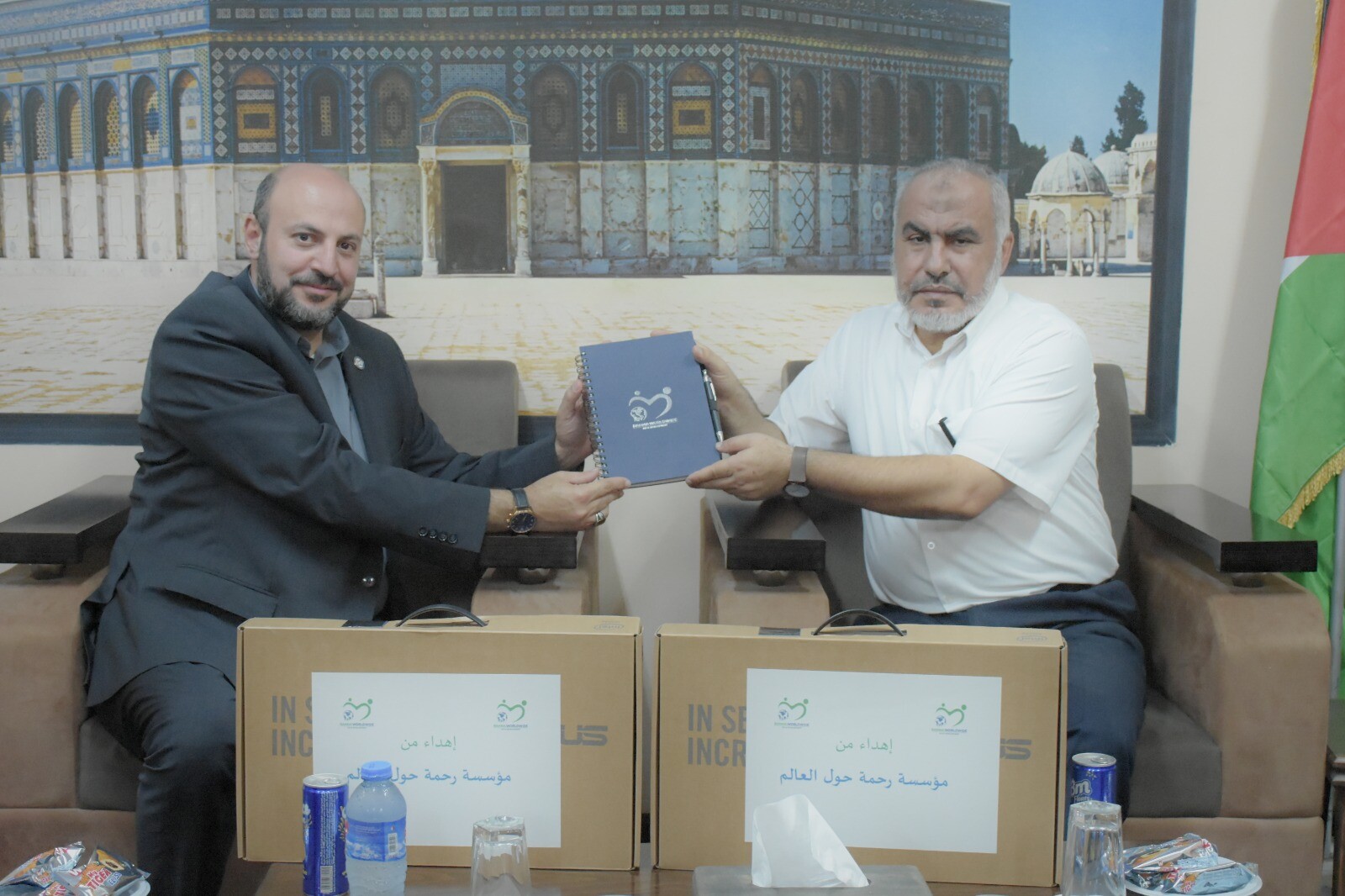 Rahma CEO Shadi Zaza hands a Rahma Worldwide product to Hamas politburo member Ghazi Hamad.