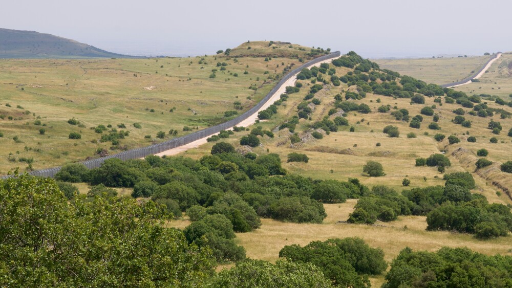 The restricted military zone along the border between Israel and Syria in a remote part of the Golan Heights. The border barbed wire fence along patrol road