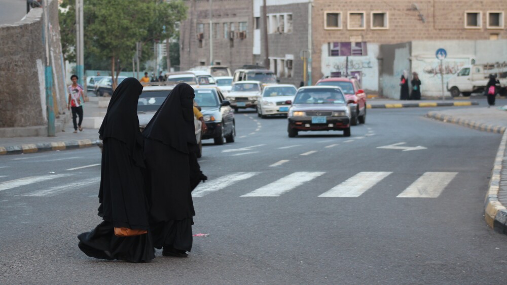 Two women cross a street in Aden, South Yemen.
